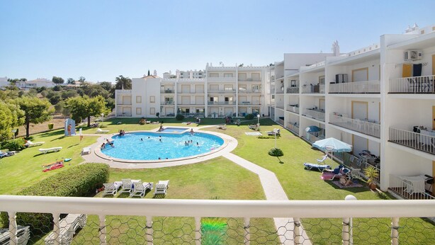 A hotel with a swimming pool, multiple balconies, and a well-maintained lawn. - Apartment 'Golden Rana' with Shared Pool, Wi-Fi and Air Conditioning (Albufeira)