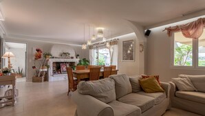 Ein Wohnzimmer mit einer Couch, einem Esstisch, Stühlen und einem Kamin.