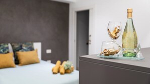 A room with a bed, a bedside table with a bottle and glasses, and a small plant. - Vacation Apartment 'Trébol' with Wi-Fi (Santa Cruz de Tenerife)