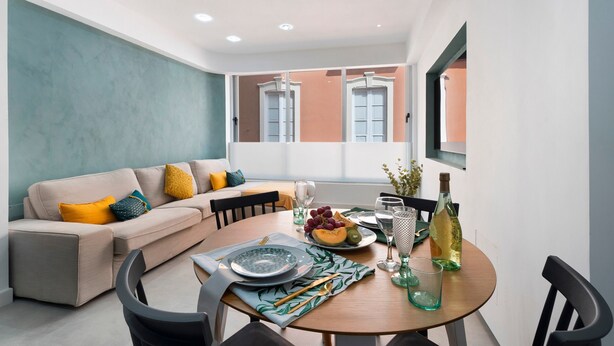 A modern living room with a sofa, dining table, and chairs. - Vacation Apartment 'Trébol' with Wi-Fi (Santa Cruz de Tenerife)