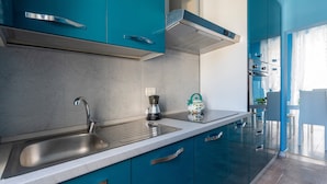 Una cocina moderna con un lavamanos de acero inoxidable, una cafetera y un horno empotrado.