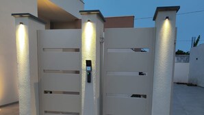 A gated entrance with a modern design, featuring a keypad lock and illuminated panels.