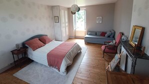 Une chambre à coucher comprenant un lit, un canapé, une chaise, un bureau et un miroir.