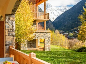 A chalet with a stone facade, wooden balcony, and a view of snow-capped mountains. - Champagny en Vanoise, 3 rooms, 6 pers., WIFI, Private Garage, Pool and SPA Access (Champagny-en-Vanoise)