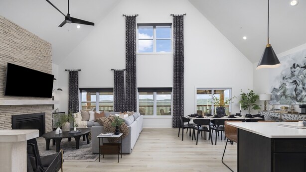 A spacious living area with a fireplace, a large sofa, a dining table, and a kitchen island.