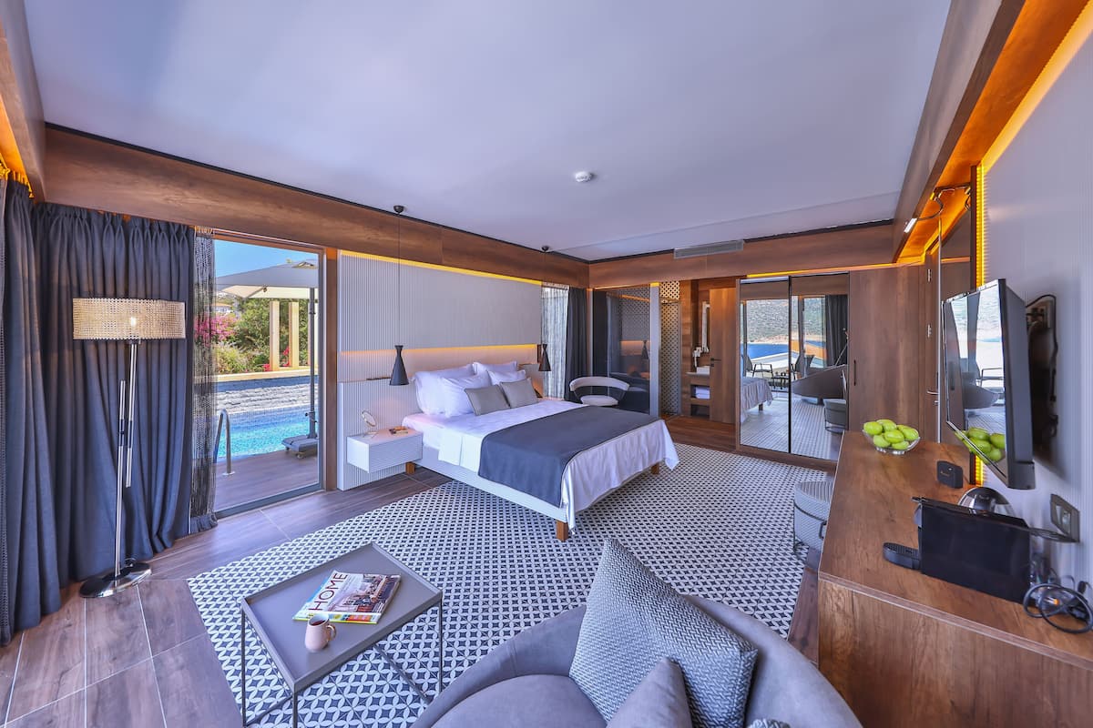 Una habitación de hotel moderna con una cama grande, un sofá, una mesa de centro y un televisor.