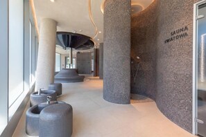 A modern spa area with a sauna, large columns, and seating.