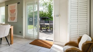 A room with a sliding glass door leading to an outdoor patio with a table and chairs.