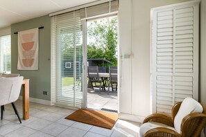 A room with a sliding glass door leading to an outdoor patio with a table and chairs.