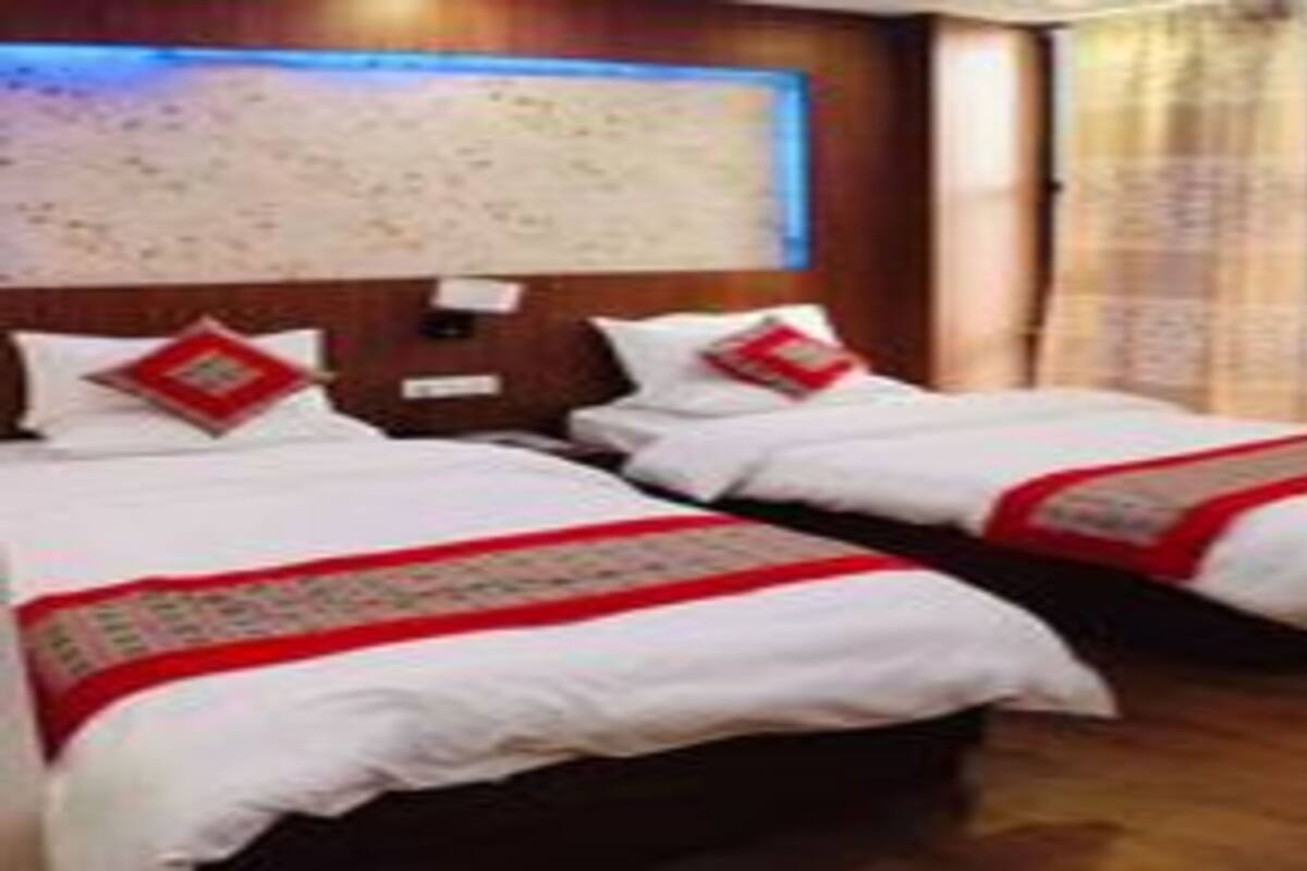 Une chambre d’hôtel avec deux lits, un plancher en bois, une grande carte murale et une fenêtre avec des rideaux.