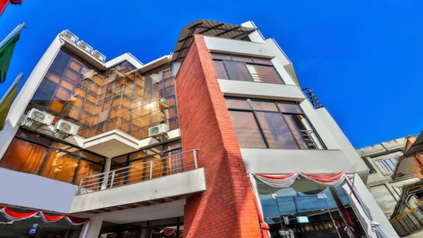 A modern building with a glass facade, a balcony, and a sign that reads "Hotel". - MeroStay 256 Hotel Mai (Kathmandu)