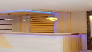 A reception desk with wooden paneling and pendant lighting. - MeroStay 256 Hotel Mai (Kathmandu)
