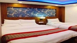 A hotel room with two beds, a wooden headboard, and a decorative wall panel. - MeroStay 256 Hotel Mai (Kathmandu)