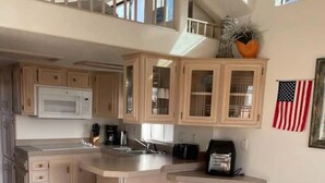 Un'ampia cucina con isola centrale, mobili in legno e disposizione su due livelli.