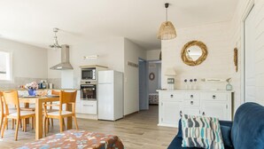 A compact living space with a dining area, kitchenette, and a sofa with a patterned throw. - Contemporary 3-bedroom house near the beach in Saint-Pair-sur-Mer (Saint-Pair-sur-Mer)