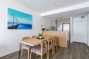 Cozy living space with a dining area, kitchenette, and large window offering a view of the outdoors.