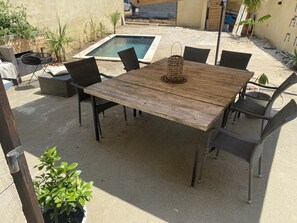 Relax in a serene outdoor space with a pool and lush greenery.