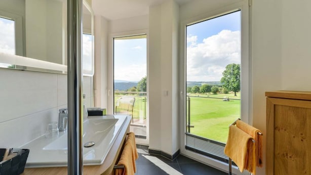 A modern bathroom with a large window, a sink, and a mirror. - Hotel & Golfrestaurant Gut Wissmannshof (Staufenberg)