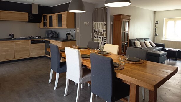 A modern kitchen with wooden cabinets, a dining table set for four, and pendant lighting. - La Talonnière, Maison de Village Avec Terrasse (Messas)