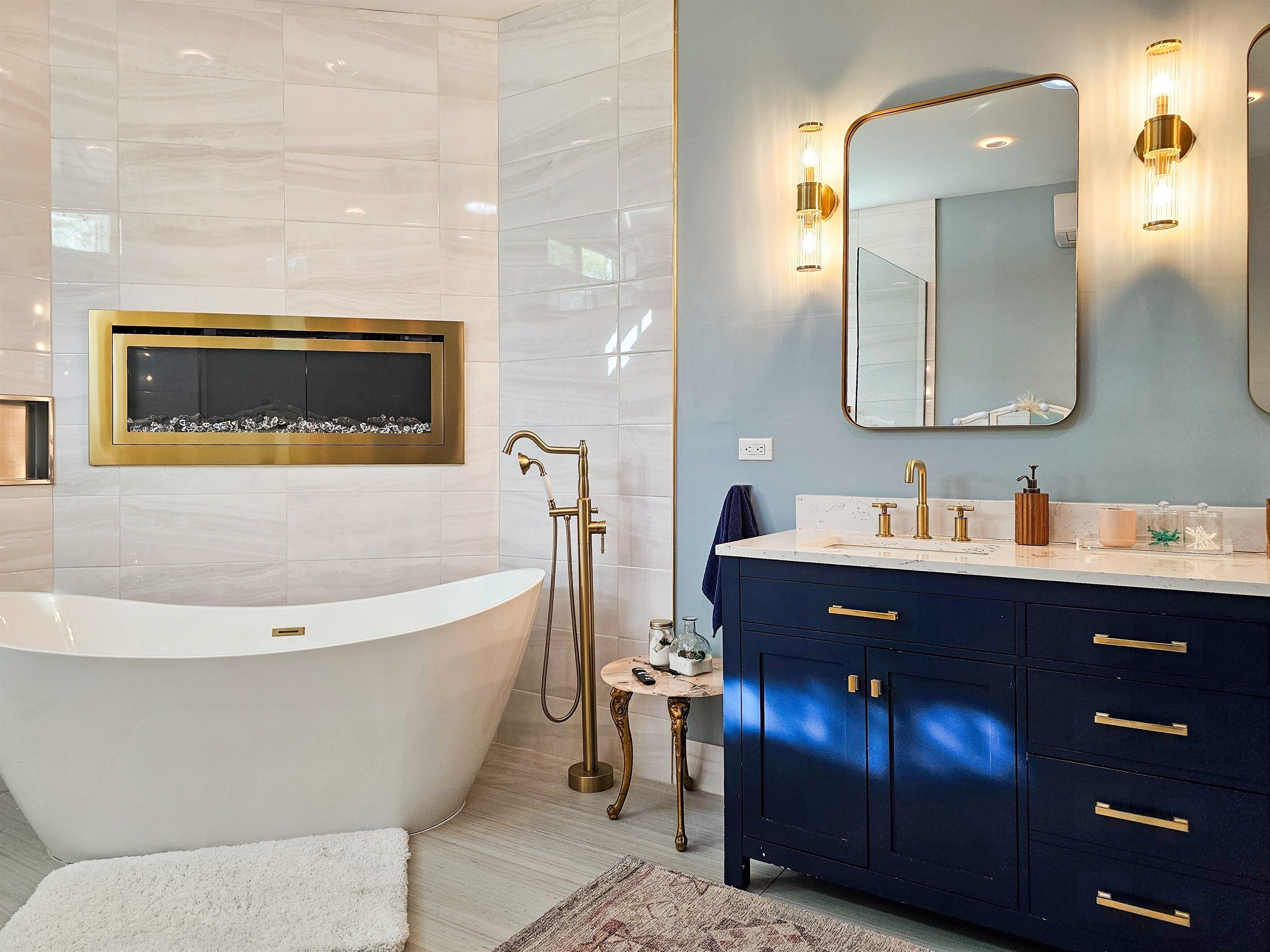Ein modernes Badezimmer mit einer freistehenden Badewanne, einem Waschtisch mit dunklem Unterschrank und einem wandmontierten Spiegel.