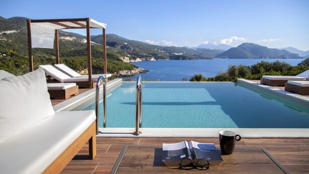 Un espace aménagé au bord de la piscine, avec une terrasse en bois, des chaises longues et une pergola.