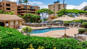 A hotel with a pool, lounge chairs, and palm trees. - Serenity framed by floor-to-ceiling Ocean views (Lahaina)