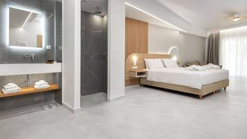 Una camera d'albergo moderna con un letto grande, bagno separato e cabina doccia.