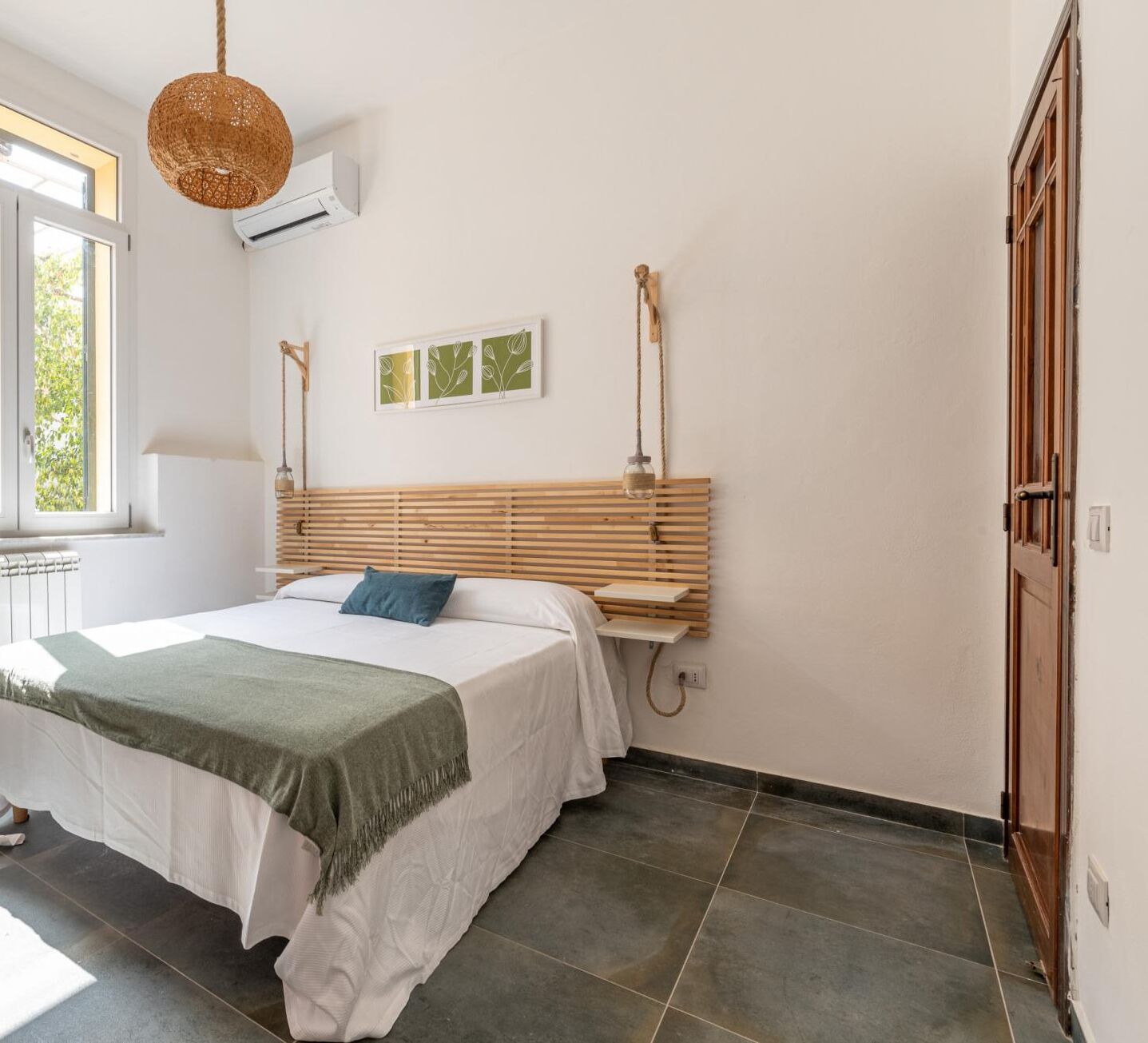 Ein Schlafzimmer mit Bett, Fenster, Klimaanlage und Tür.