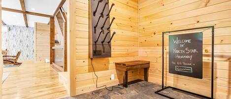 Un interior de madera con un letrero de pizarra que dice "WELCOME to North Star Hideaway" y un banco de madera.