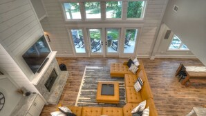 A spacious living room with a large sectional sofa, a fireplace, and a view of the outdoor patio through large sliding doors.
