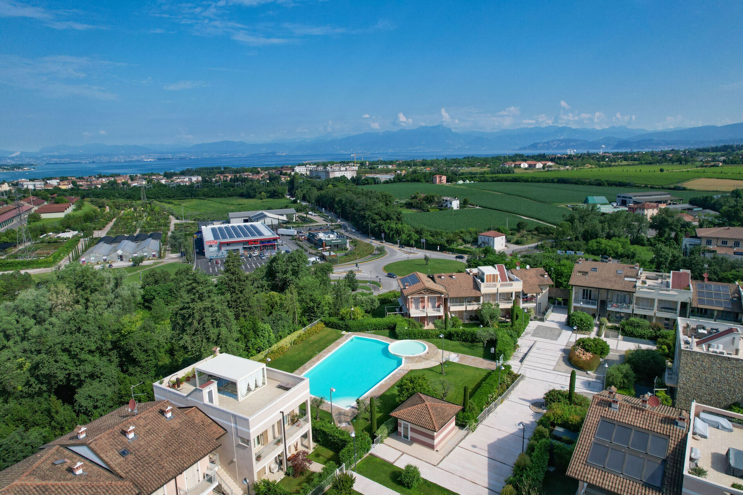 Ein Wohngebiet mit Pool, Solaranlage und Blick auf ferne Berge.