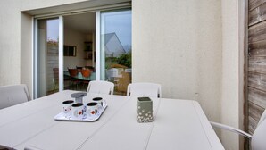 Et hvidt bord med en bakke, tre kopper og en vase.