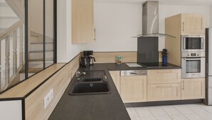 Eine moderne Küche mit Geschirrspüler, doppelter Spüle und Edelstahlgeräten.
