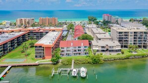 Un hotel costero con varias edificaciones, un puerto deportivo y vista al océano.