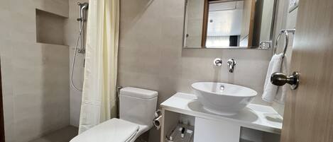 Ein modernes Badezimmer mit Toilette, Waschbecken und Dusche.