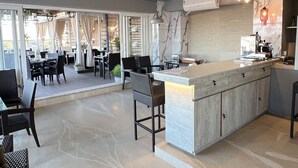 A spacious indoor area with a central island counter, seating arrangements, and a view of the outdoors. - Aurora Boutique Hotel (Imphal)
