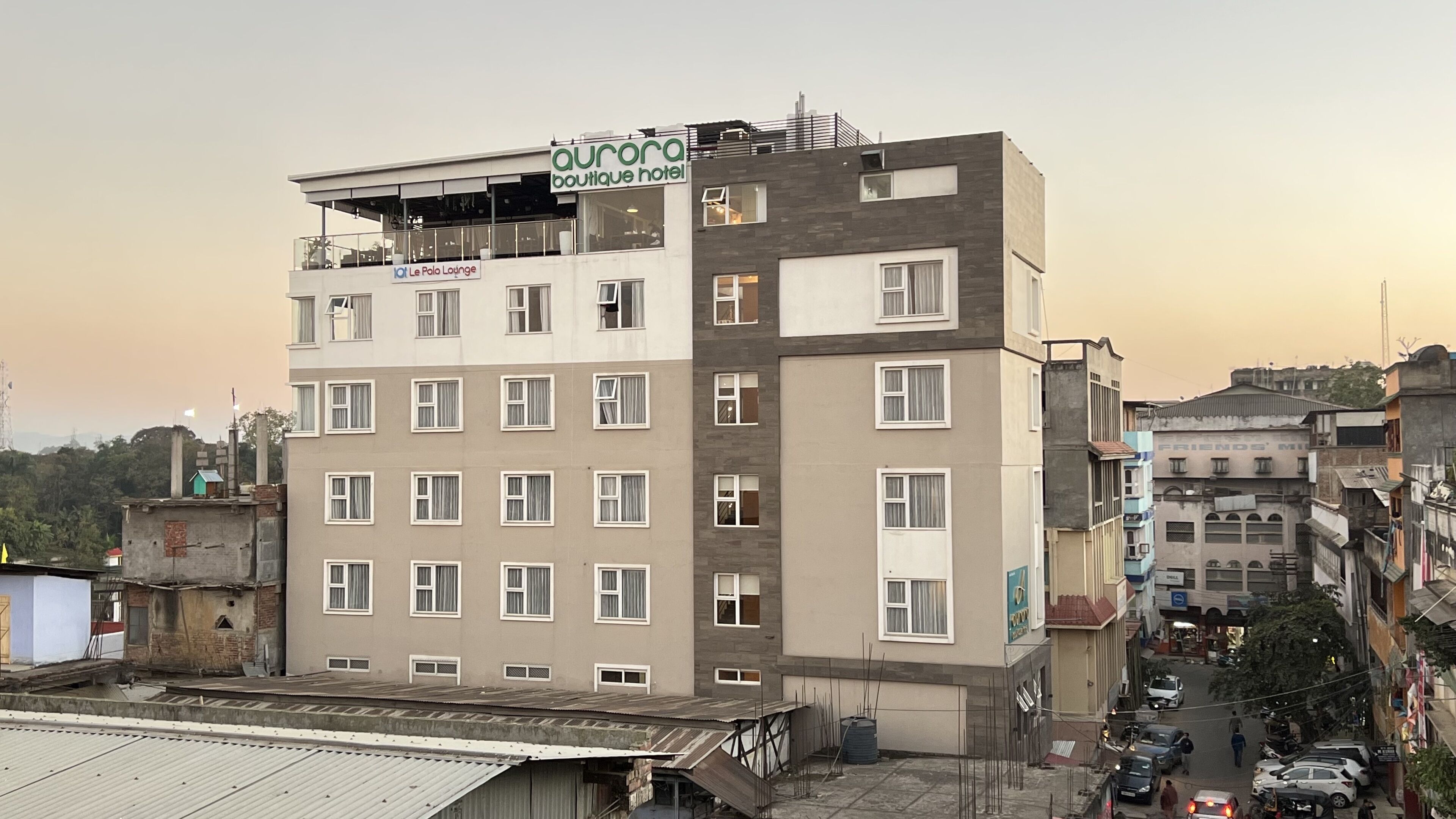Un hotel de varios pisos con un letrero que dice 'Aurora Boutique Hotel' y '101 Le Polo Lounge'.