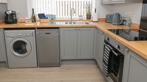 Una cocina compacta equipada con lavadora, lavavajillas y horno.