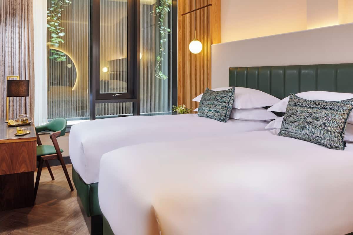 Ein Hotelzimmer mit einem großen Bett, einem Schreibtisch und einem Stuhl.