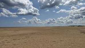 A vast, open sandy landscape with a clear sky and scattered clouds. - 3-bed Caravan Near Mablethorpe (Louth)