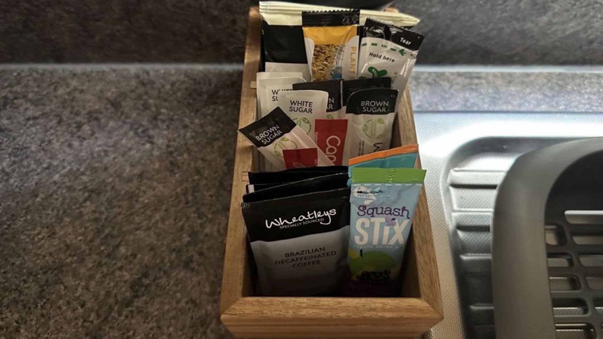 En trälåda som innehåller olika sorters kaffepaket.