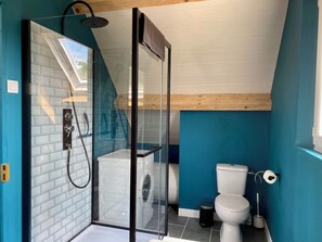 Een douche, handdoeken, zeep, toiletpapier