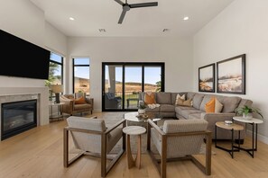 A spacious living room with a fireplace, a large sofa, and a television.