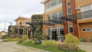 A hotel with a modern facade, large windows, and a vertical garden feature.