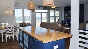 Eine moderne Küche mit einer Holztheke, blauen Schränken und Korbtropfenlampen.