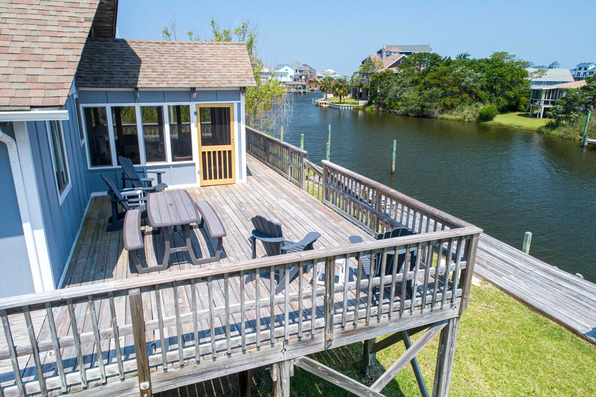 A deck with outdoor seating and a view of a river.