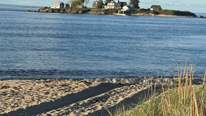 A coastal scene with a sandy beach and a row of houses by the water. - Biddeford Pool Beach Condo - Steps to the Sand - 1BR/1BA (Biddeford)