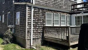 A two-story wooden house with a fenced deck and a garage. - Biddeford Pool Beach Condo - Steps to the Sand - 1BR/1BA (Biddeford)
