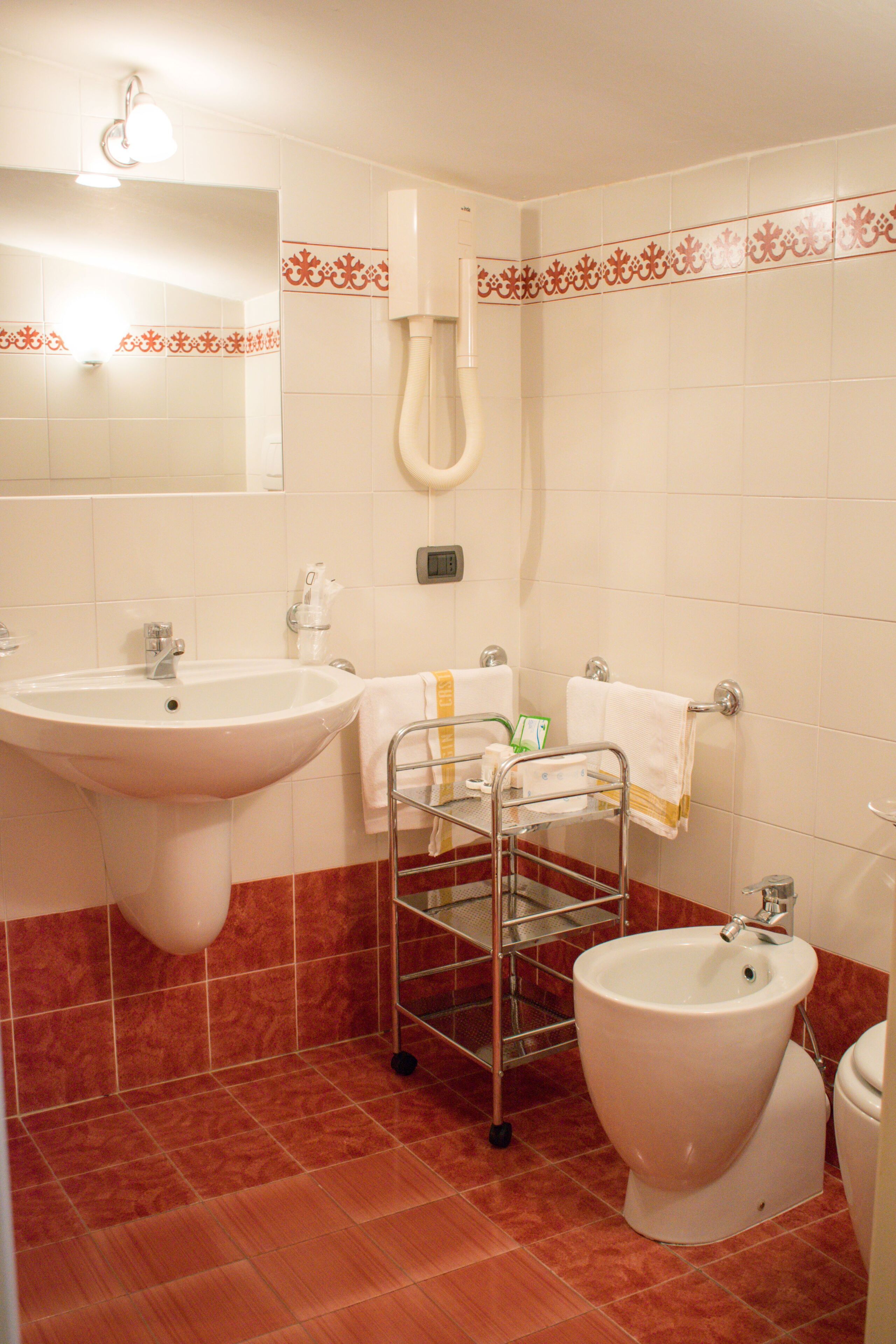 Un bagno con lavandino, bidet e porta asciugamani.