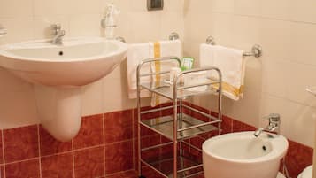 Un bagno con lavandino, bidet e porta asciugamani.